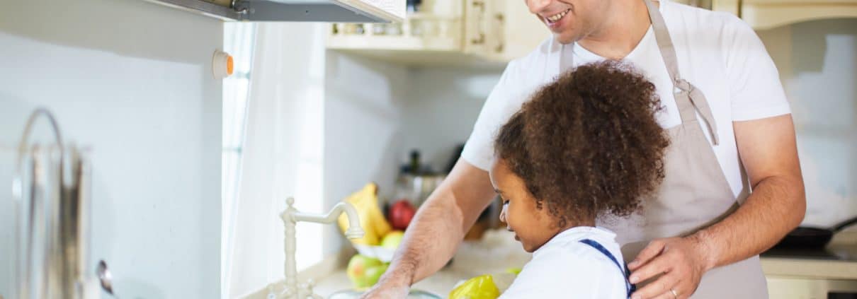 Father daughter cleaning dishes in Airbnb